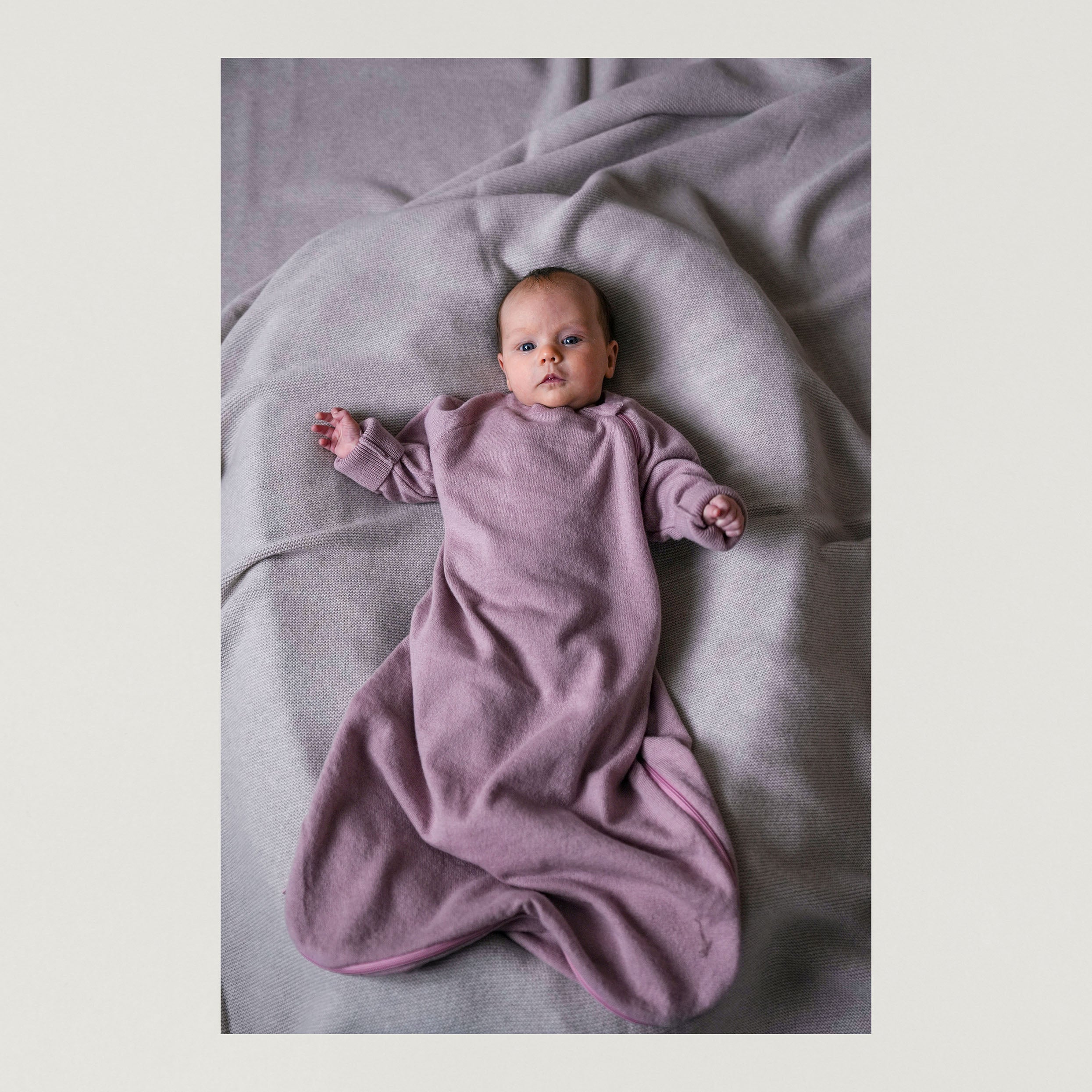 Foto mit Baby welches den Babyschlafsack in spring rose traegt