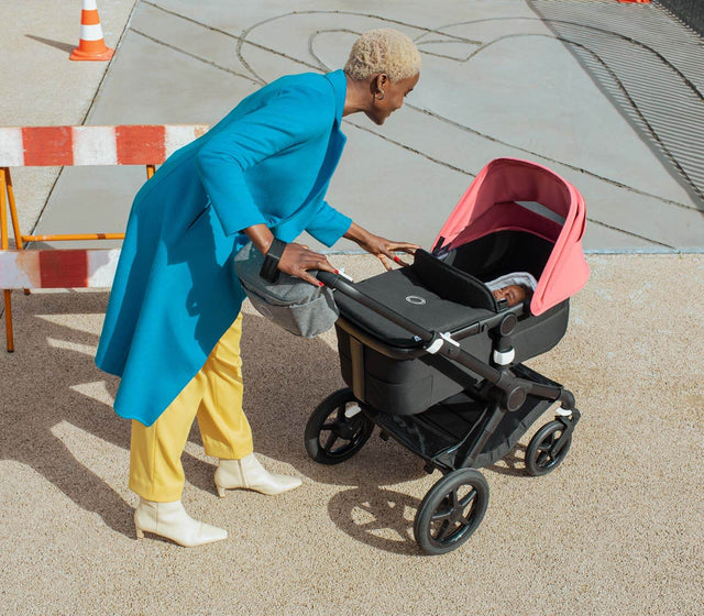 Bild Mutter die mit dem Baby im Kinderwagen interagiert