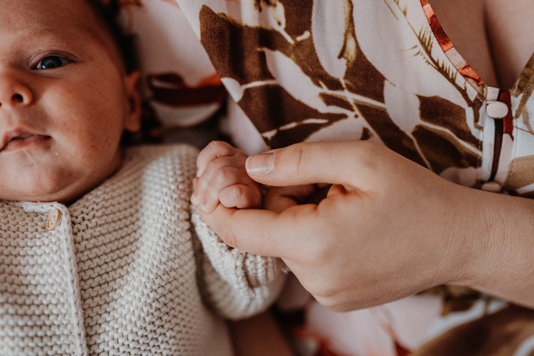 Bild eines Babys das die Hand der Mutter hält