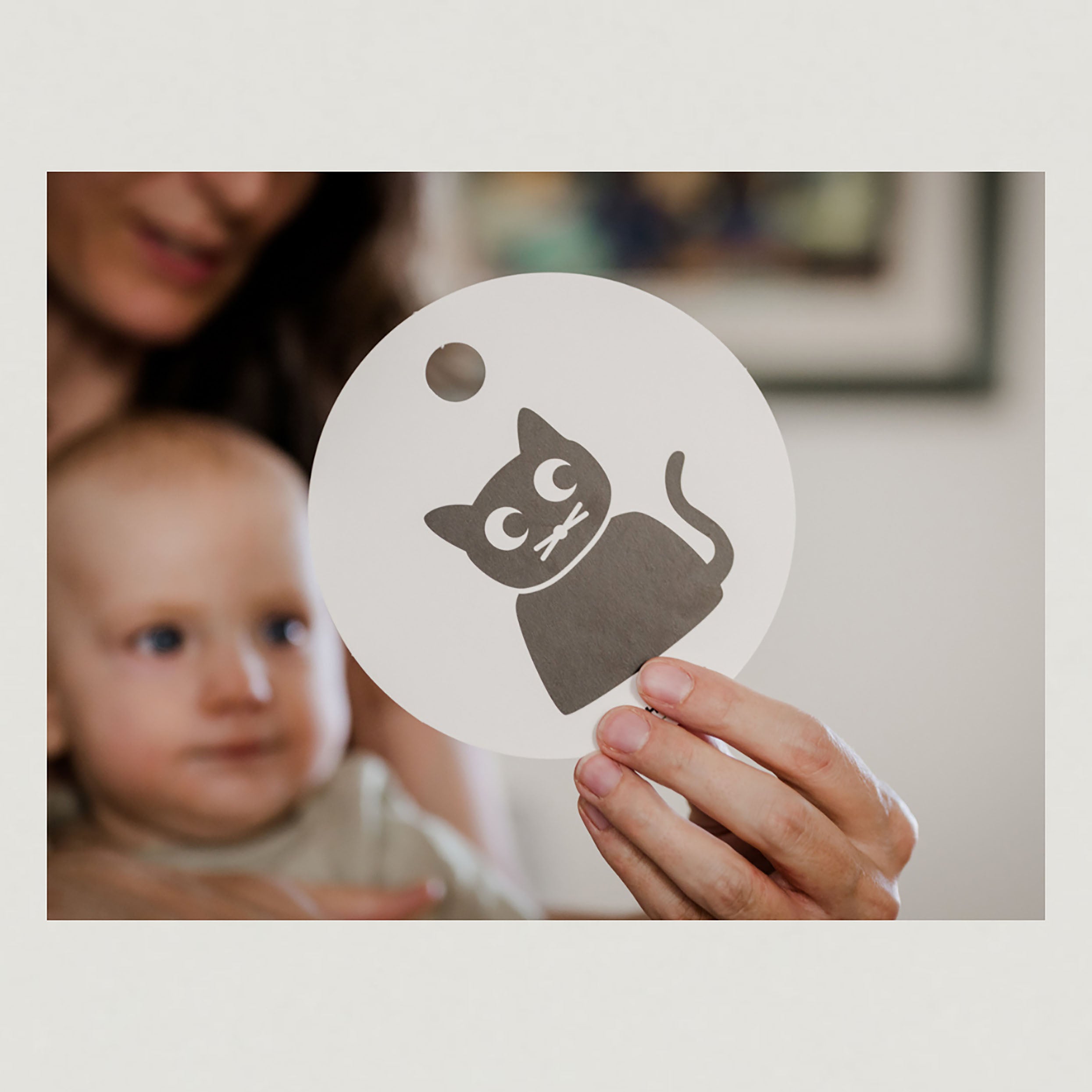 Foto mit Baby welches eine Kontrastkarte vorgehalten bekommt