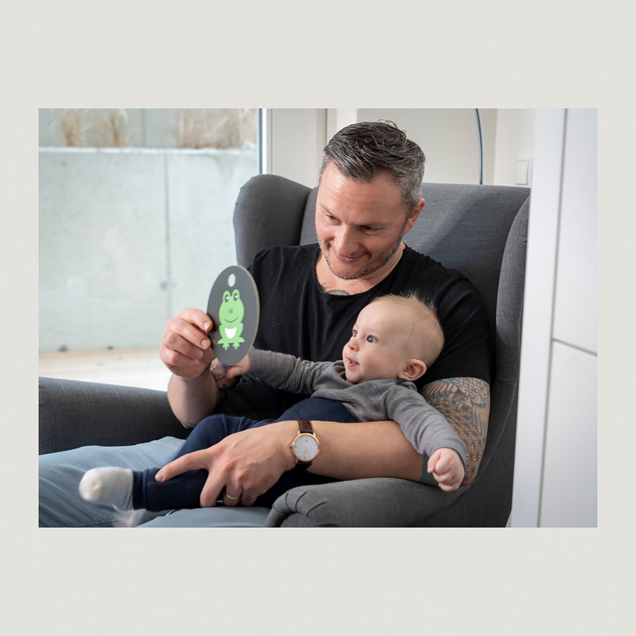 Foto Mann mit Baby auf dem Arm und Kontrastkarte