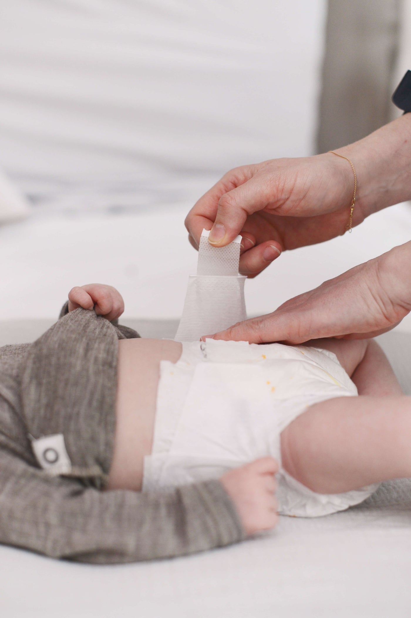 Baby auf dem Wickeltisch wird gewickelt