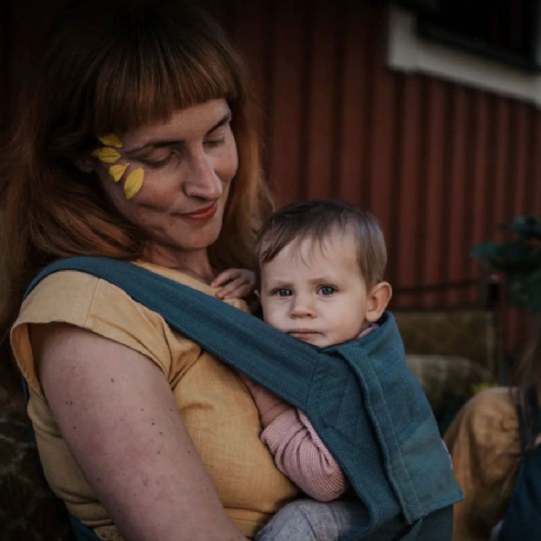 Foto einer Frau mit Kind in der Trage