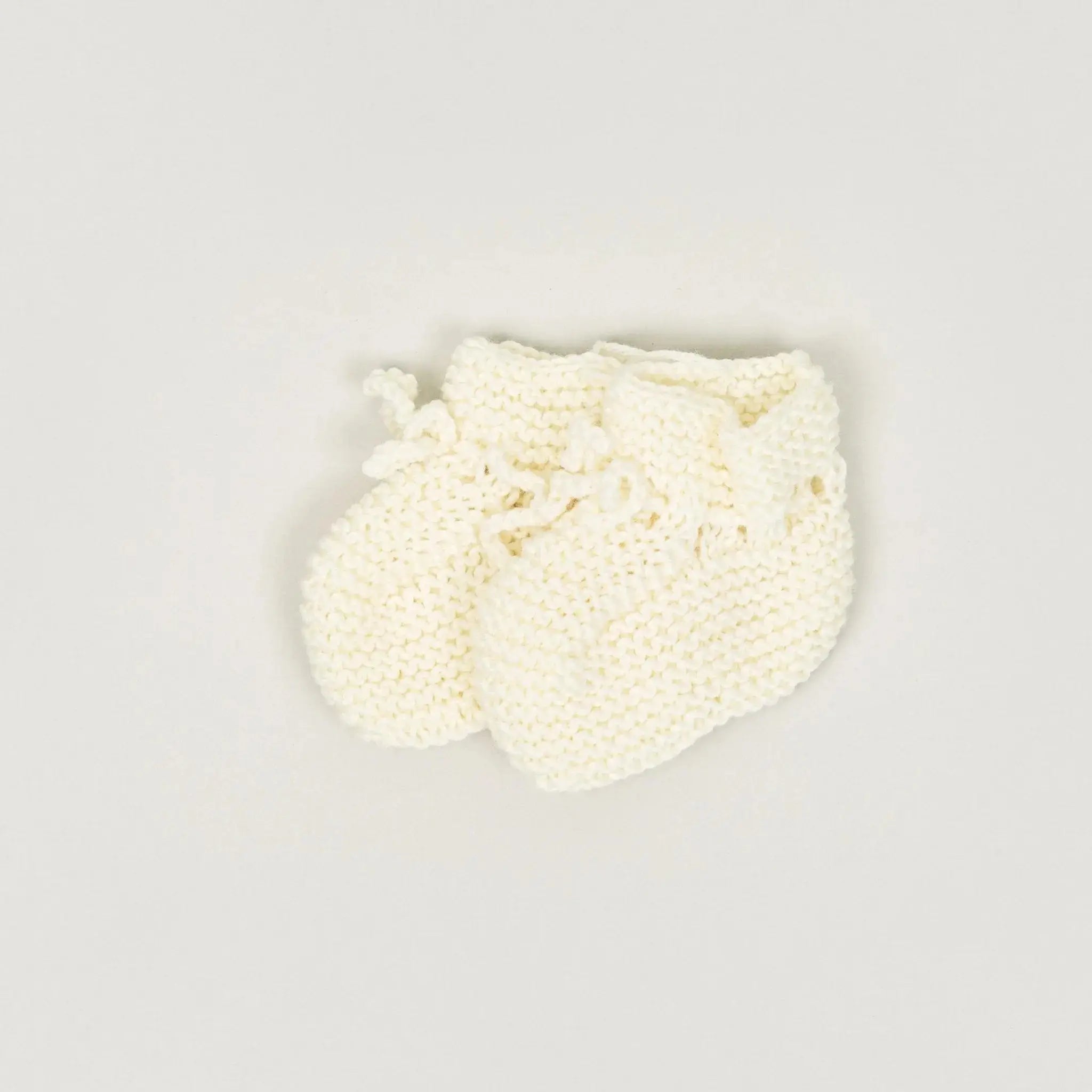 Ein Paar handgestrickte Schuhe aus der Babybox Handmade Collection in der Farbe nature in der Größe 56/62
