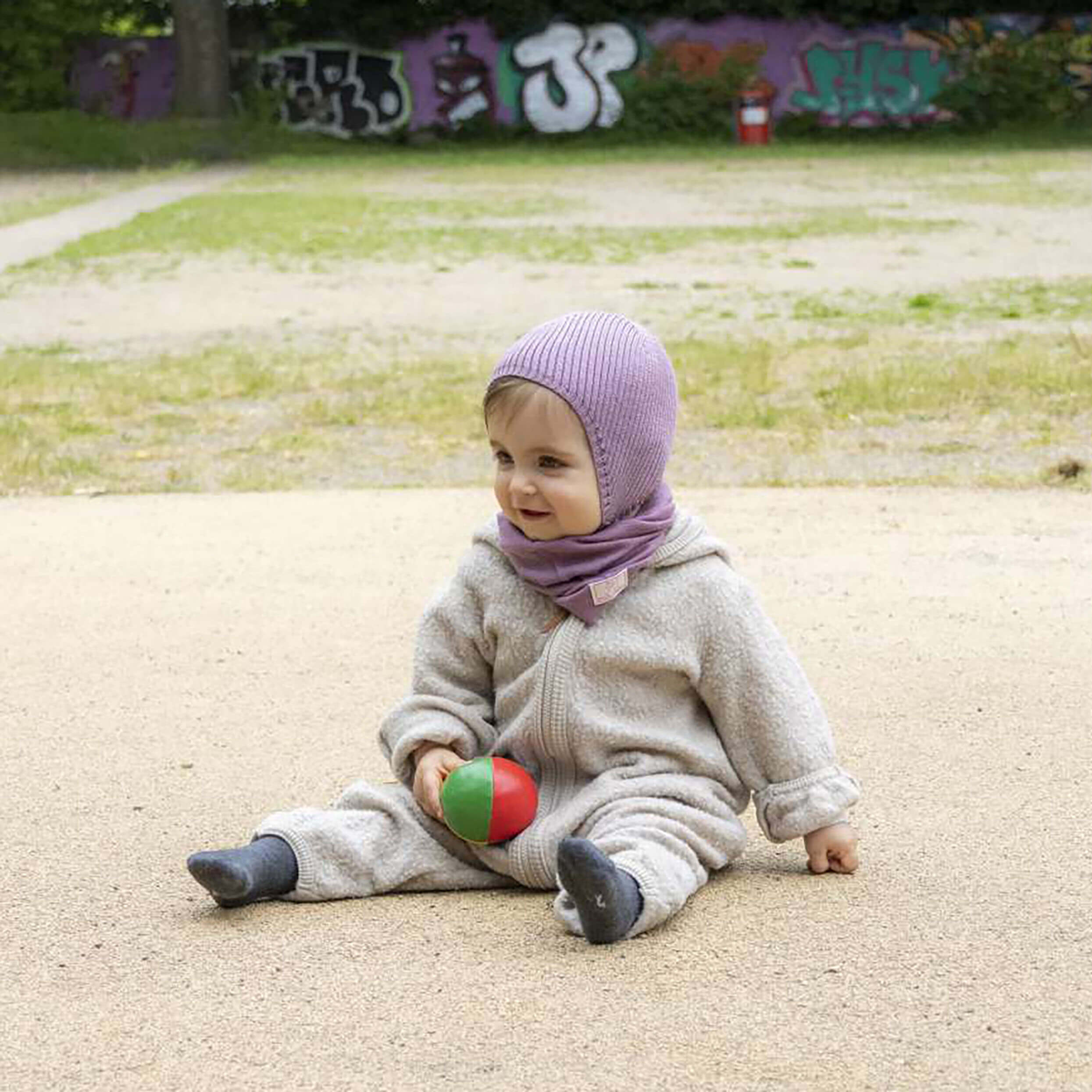 Baby mit einer Mütze in altrosa