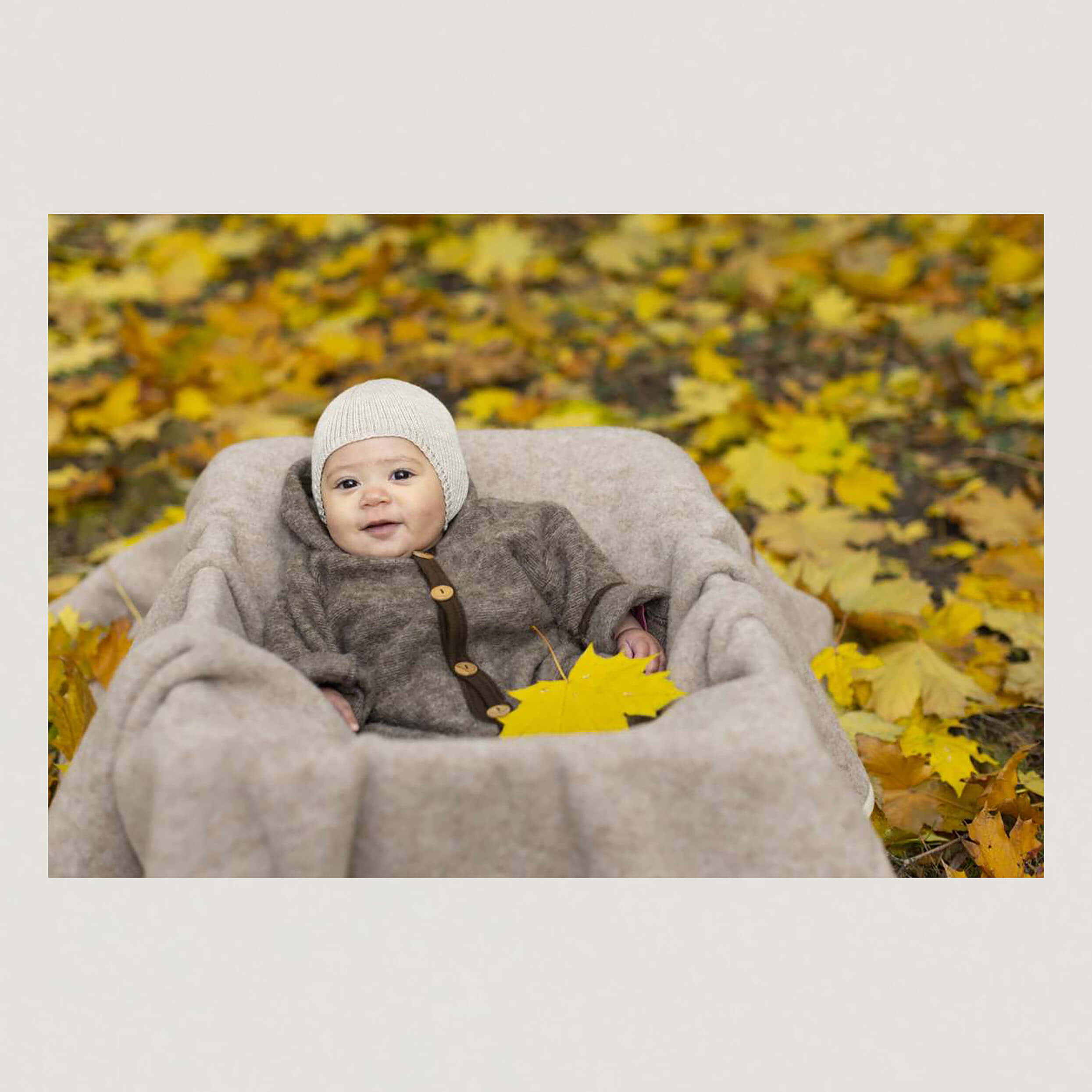 Baby mit Mütze in nature melange