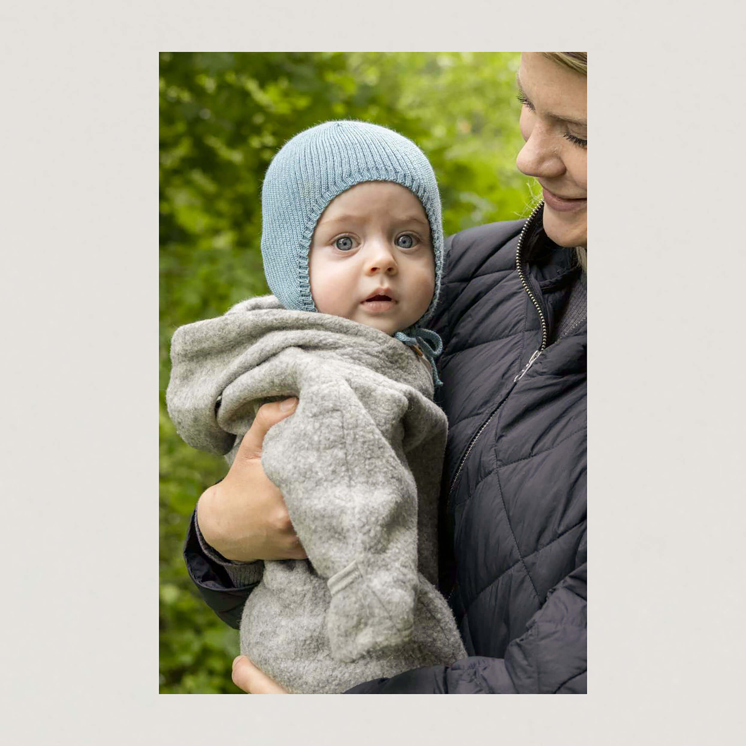Baby mit Mütze in der Farbe rauchblau