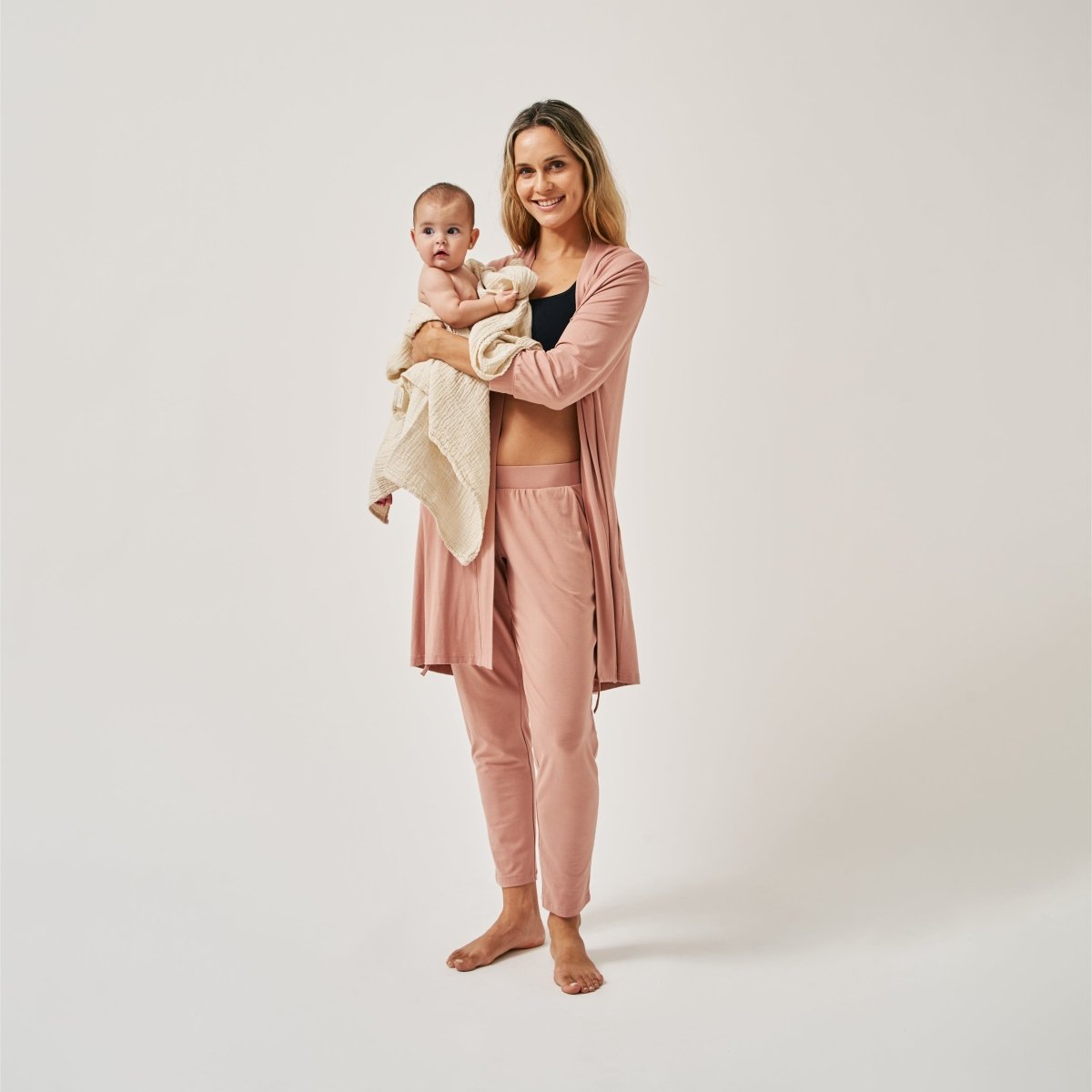 Produktfoto The Mama Set Robe blush angezogen mit Hose und Baby auf dem Arm