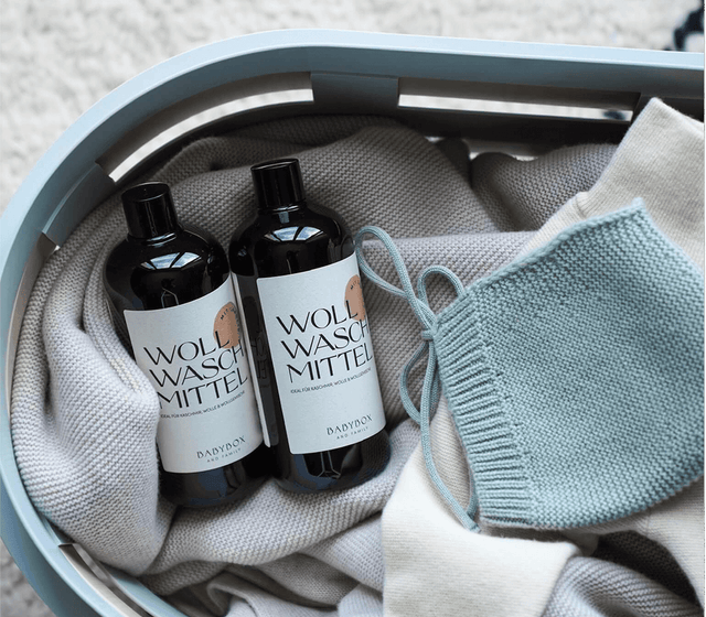 Bild mit Waschmittel mit Lanolin aus der Babybox Collection in einem Wäschekorb