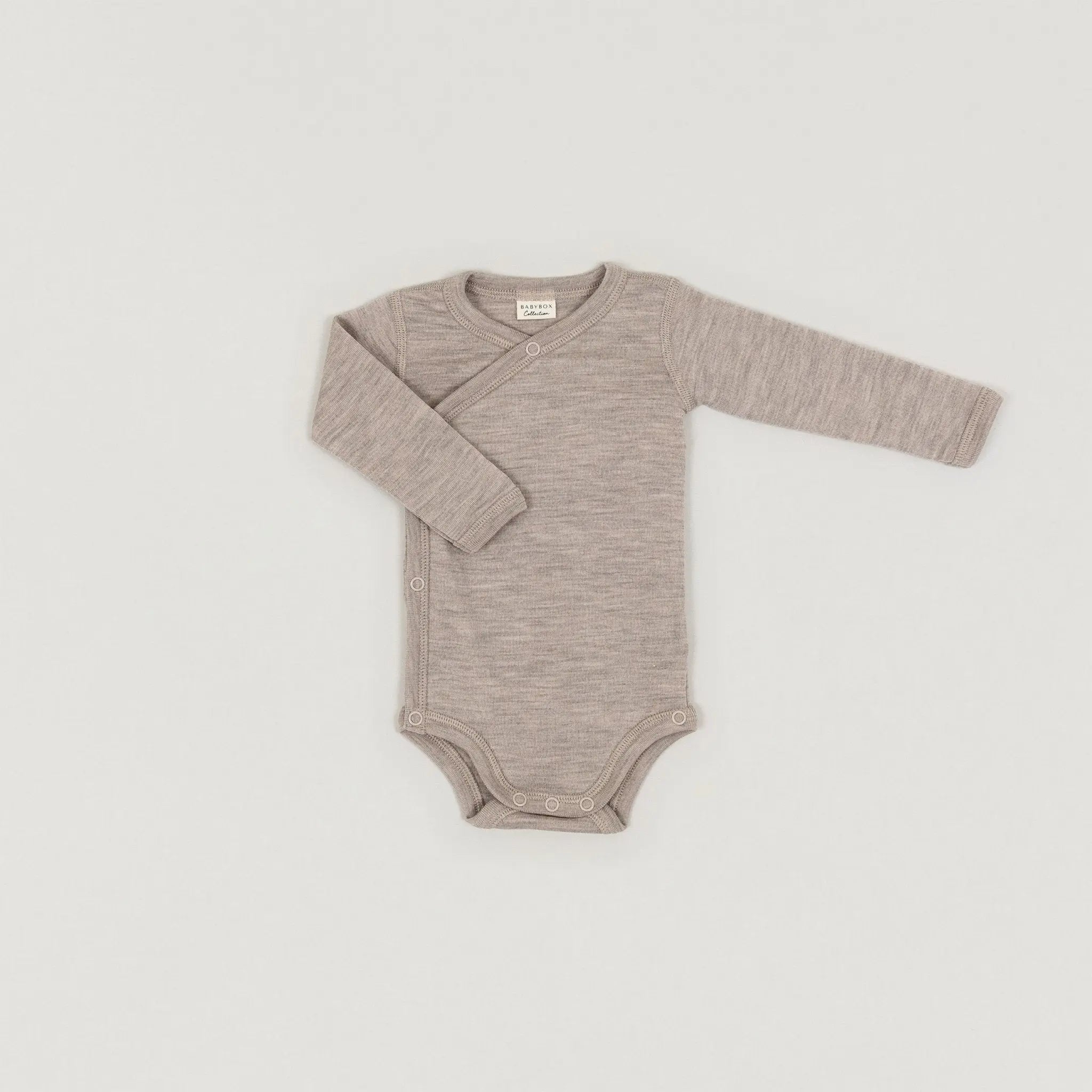 Ein Produktbild des Langarmwickelbodys aus Wolle und Seide in Dune-Melange der Babybox Collection in der Vorderansicht im Onlineshop von Babybox and Family