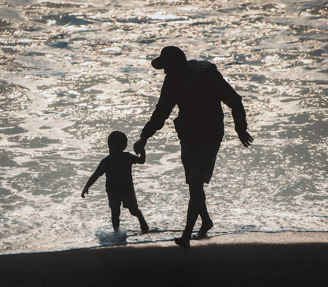 Foto Mann mit Kind an der hand am Strand