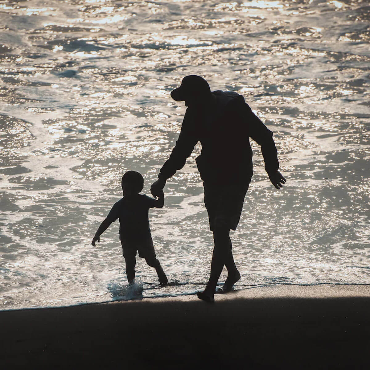 Foto Mann mit Kind an der hand am Strand