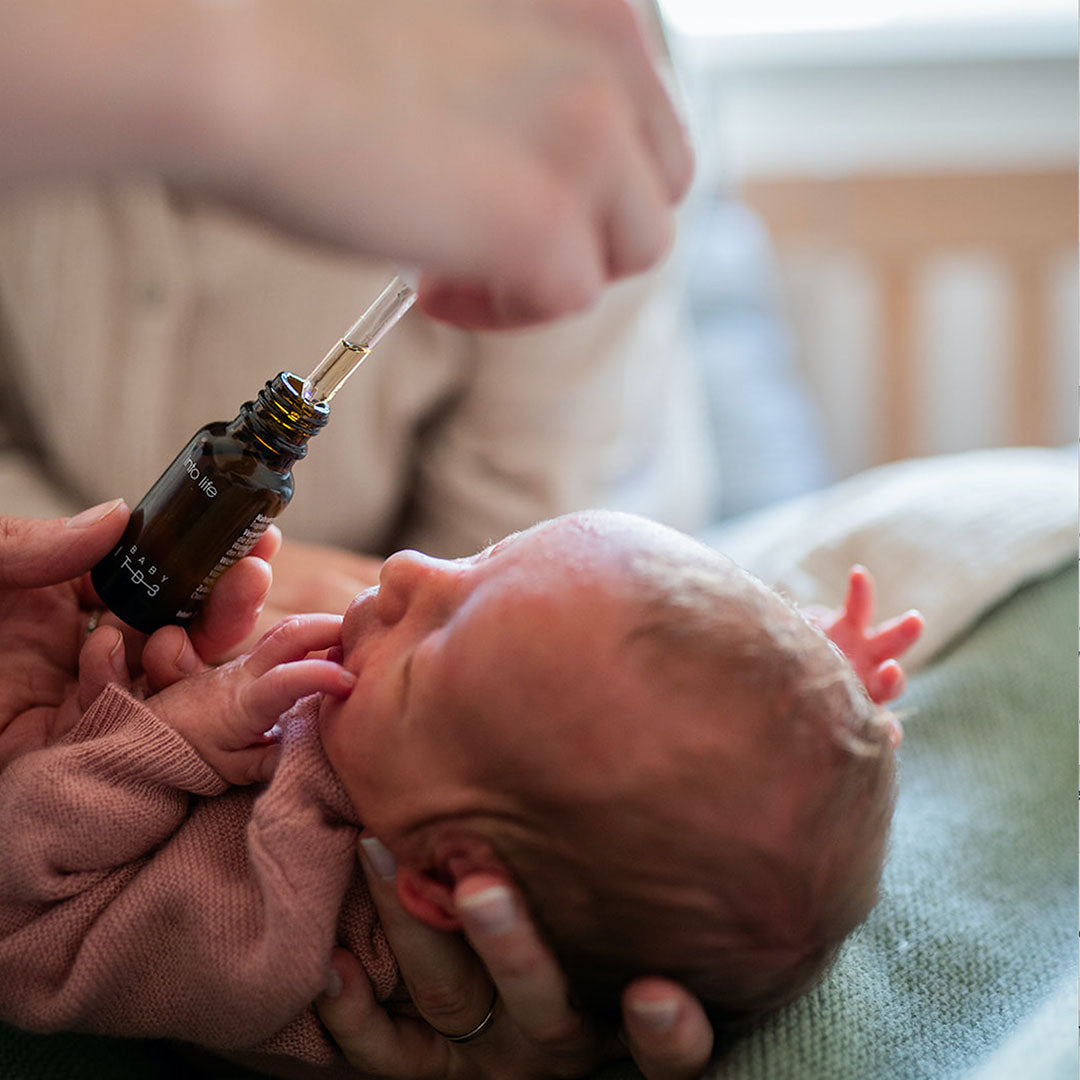 Baby bekommt Vitamin D mit einer Pipette verabreicht.