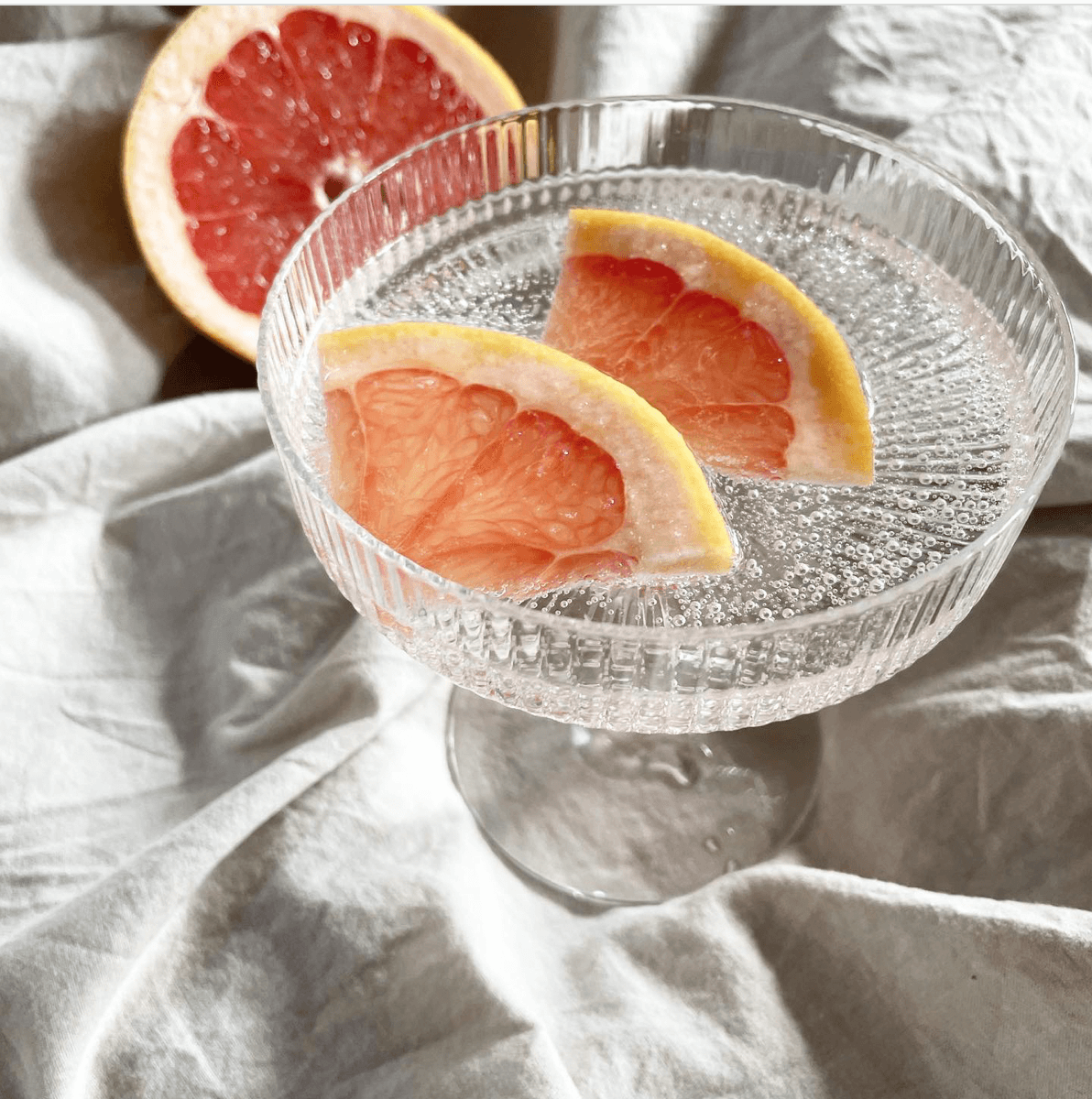 Foto mit Wasserglas und Grapefruitstücken
