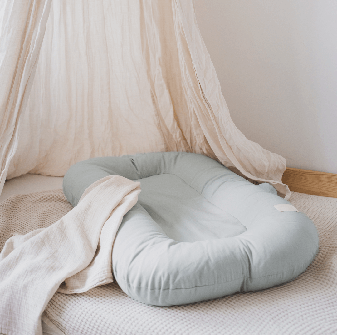 Hogi Nest in der Farbe Sage mit Himmel auf einem Bett