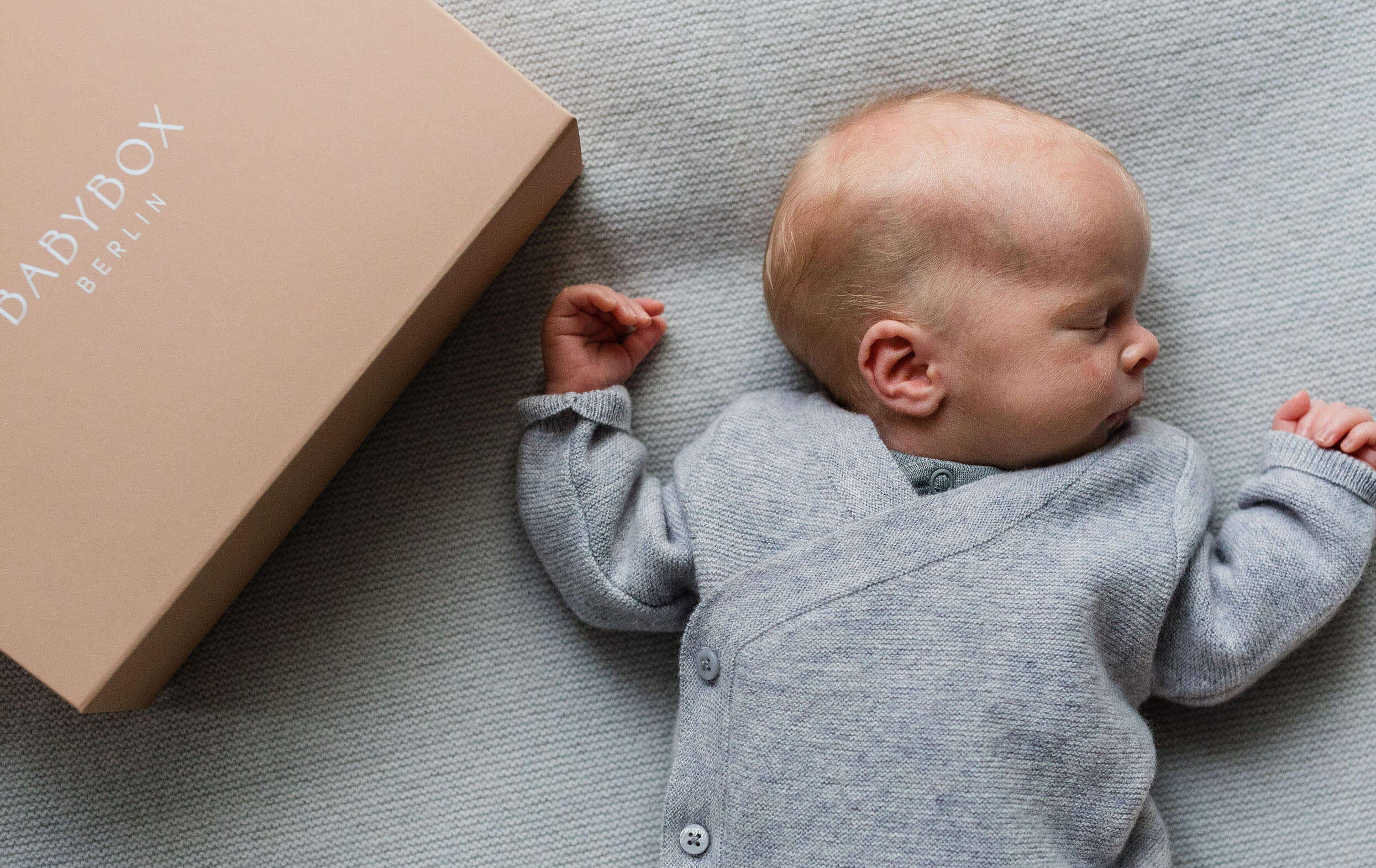Babybox Signature Box mit Baby in Hellgrauer Babybox Jacke