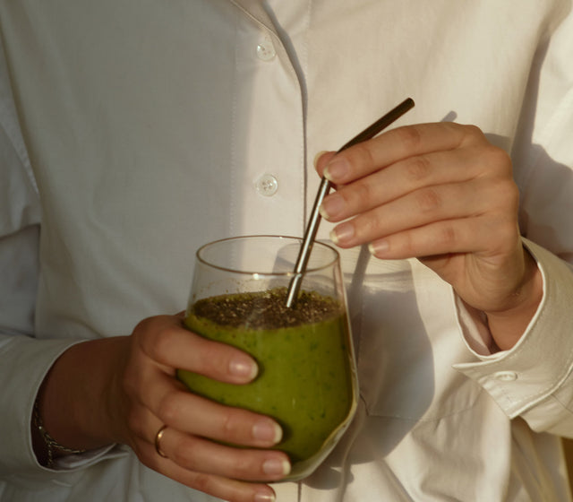 Bild einer Frau die ein Glas Matcha in der Hand hält