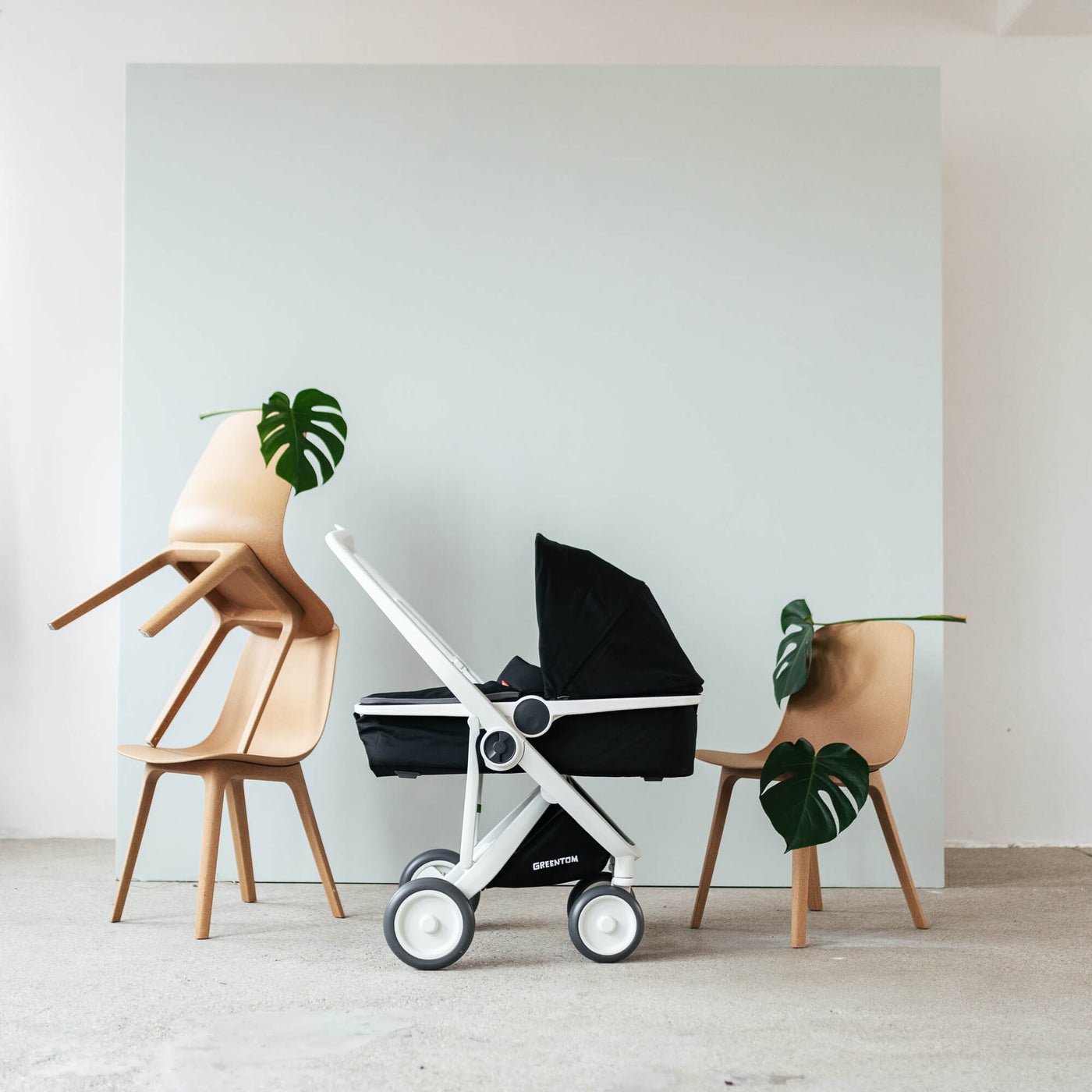 Foto eines Kinderwagen vor einer Wand mit Stühlen dekoriert