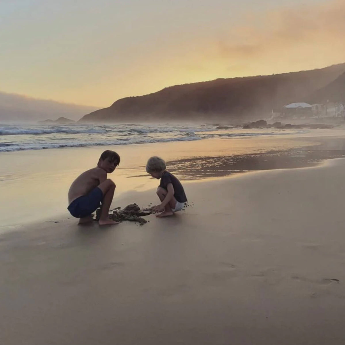 Foto zwei Kinder spielen im Sonnenuntergang am Strand