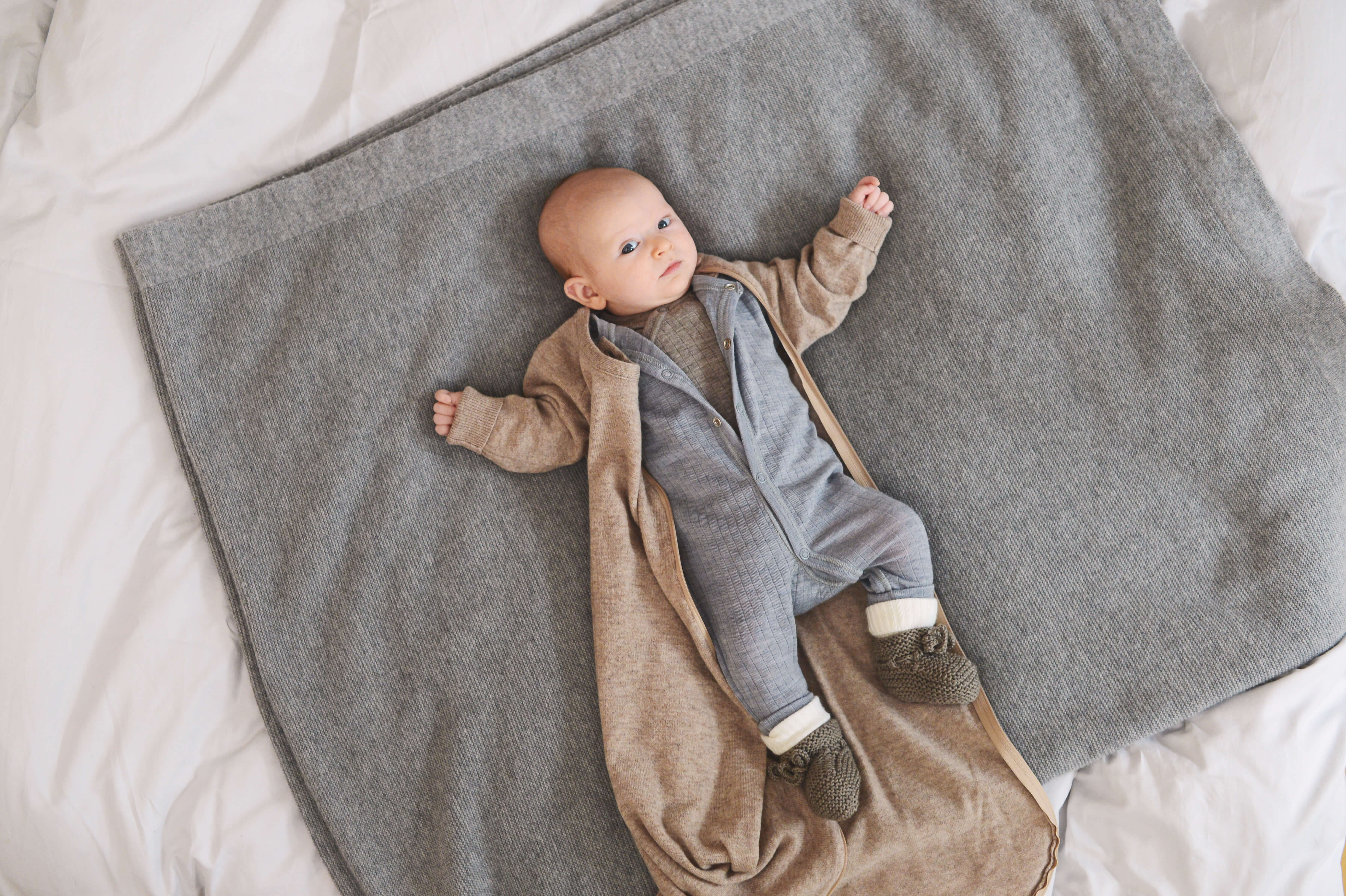 Bild eines Babys im Schlafanzug auf einer Decke